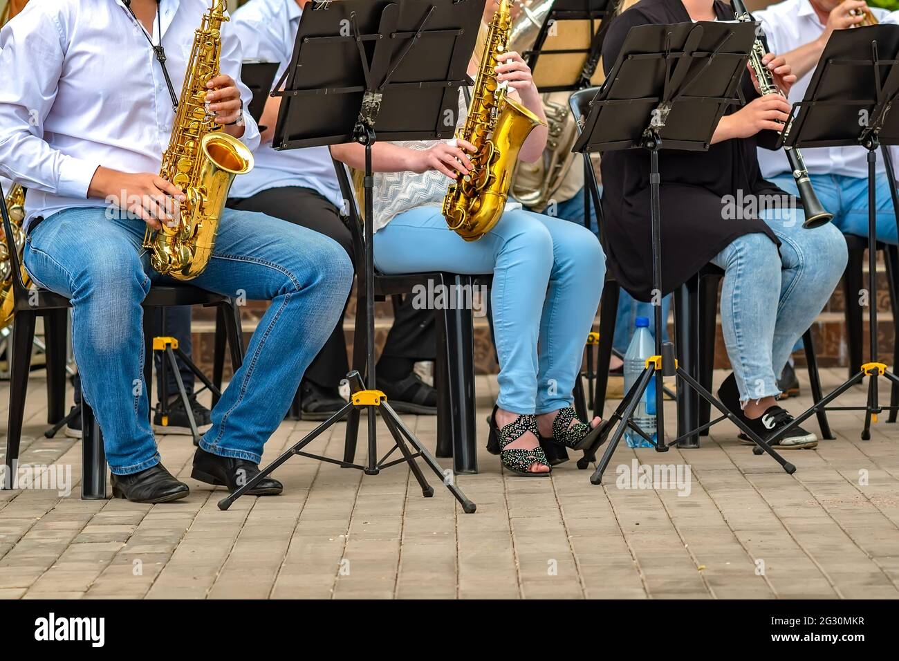 vue d'un groupe de personnes d'un groupe musical de cuivres assis sur des chaises et jouant de la musique, du jazz Banque D'Images