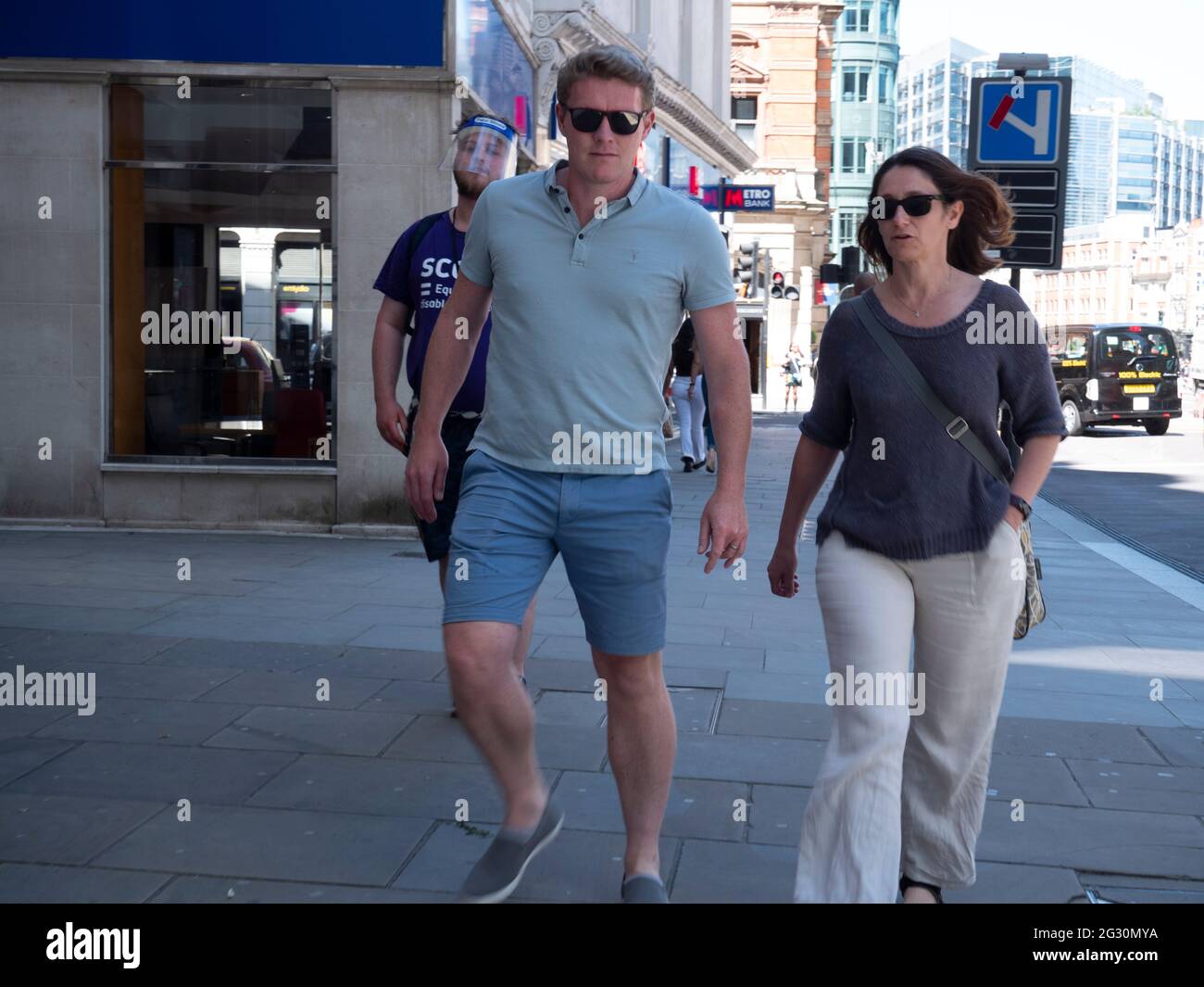 Collectionneur de collecte de fonds de charité également connu sous le nom de Chuggers, travaillant pour Scope, observant le couple marchant loin Banque D'Images