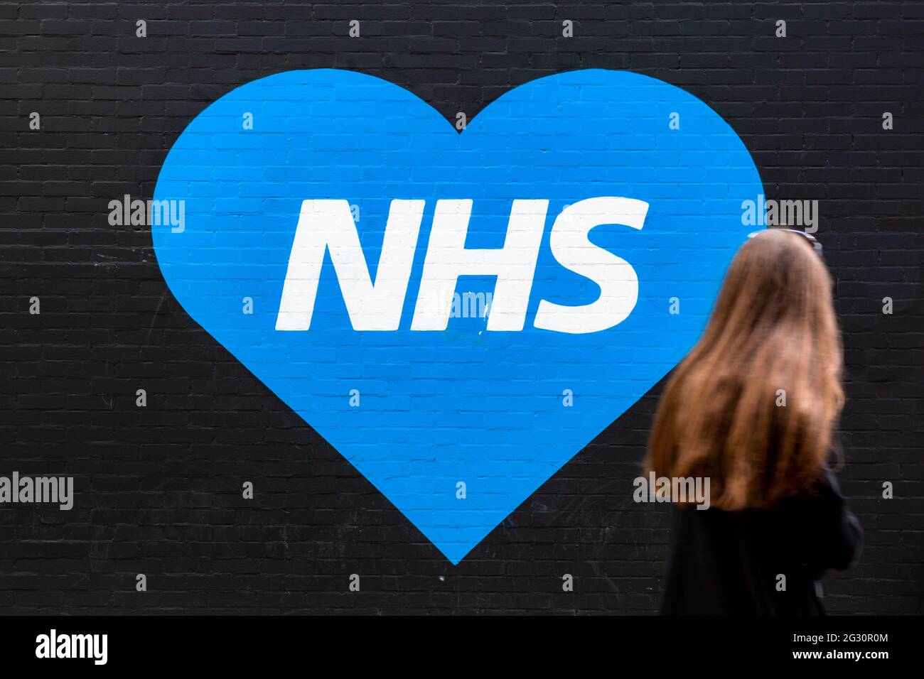 Logo NHS dans un cœur bleu, peint sur un mur extérieur, Royaume-Uni, 2021 Banque D'Images