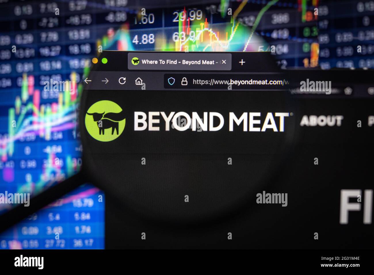 Beyond Meat Company logo sur un site Web avec des développements flous du marché boursier en arrière-plan, vu sur un écran d'ordinateur à travers une loupe Banque D'Images