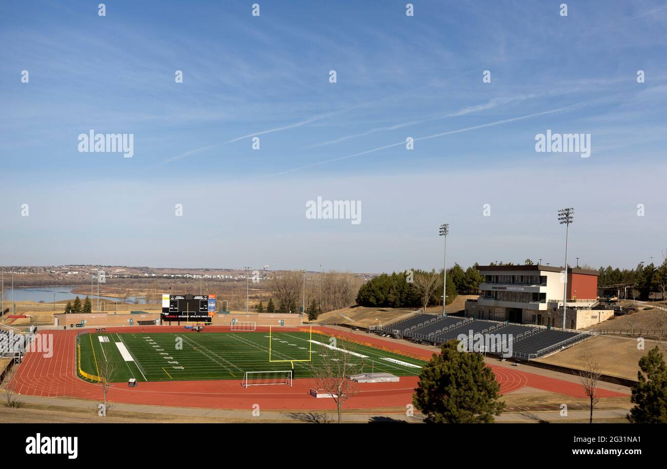 Complexe sportif américain comprenant un stade de football avec terrain d'herbe artificielle, piste de course à pied et stands au Bismarck State College, Dakota du Nord Banque D'Images