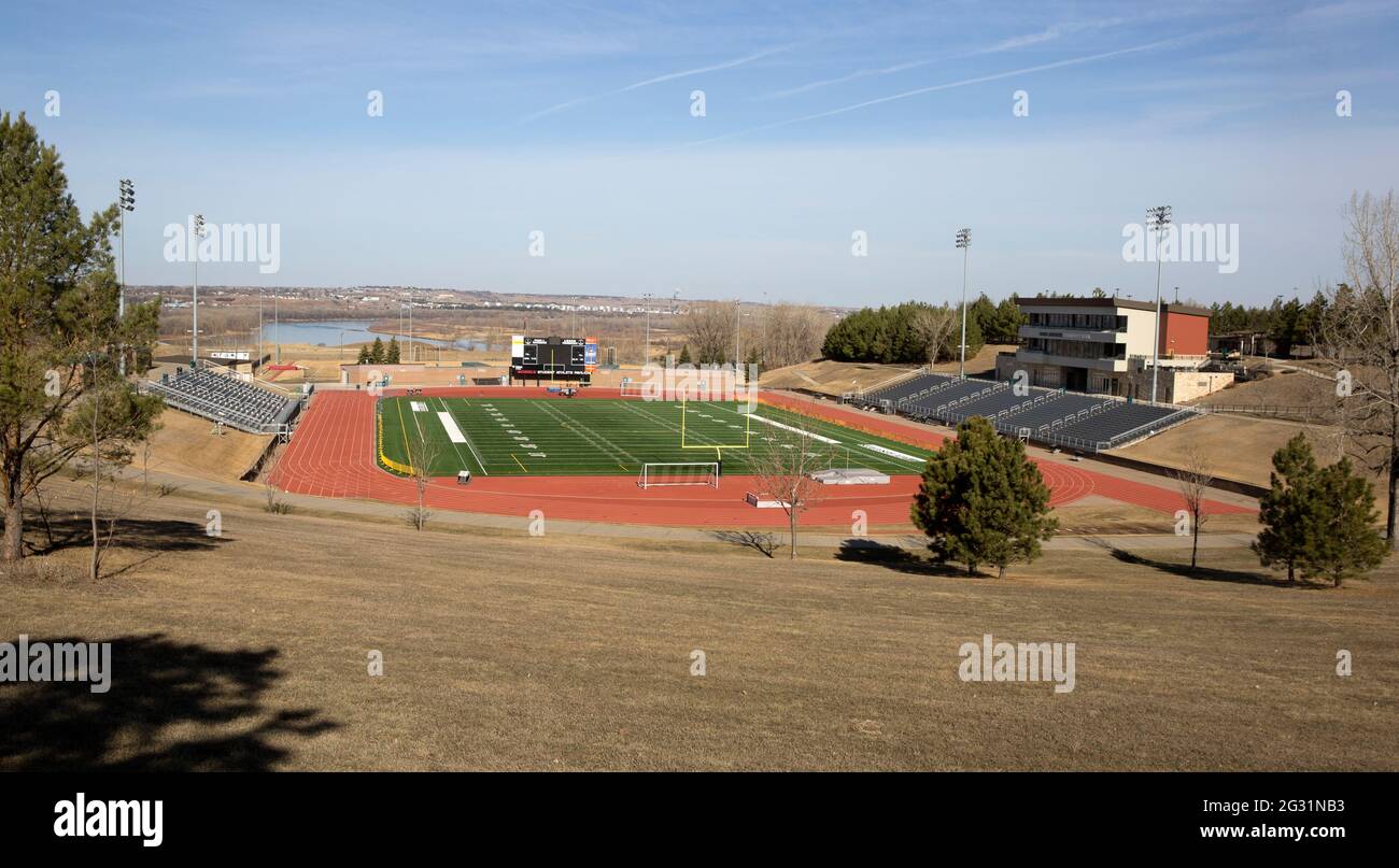 Complexe sportif américain comprenant un stade de football avec terrain d'herbe artificielle, piste de course à pied et stands au Bismarck State College, Dakota du Nord Banque D'Images