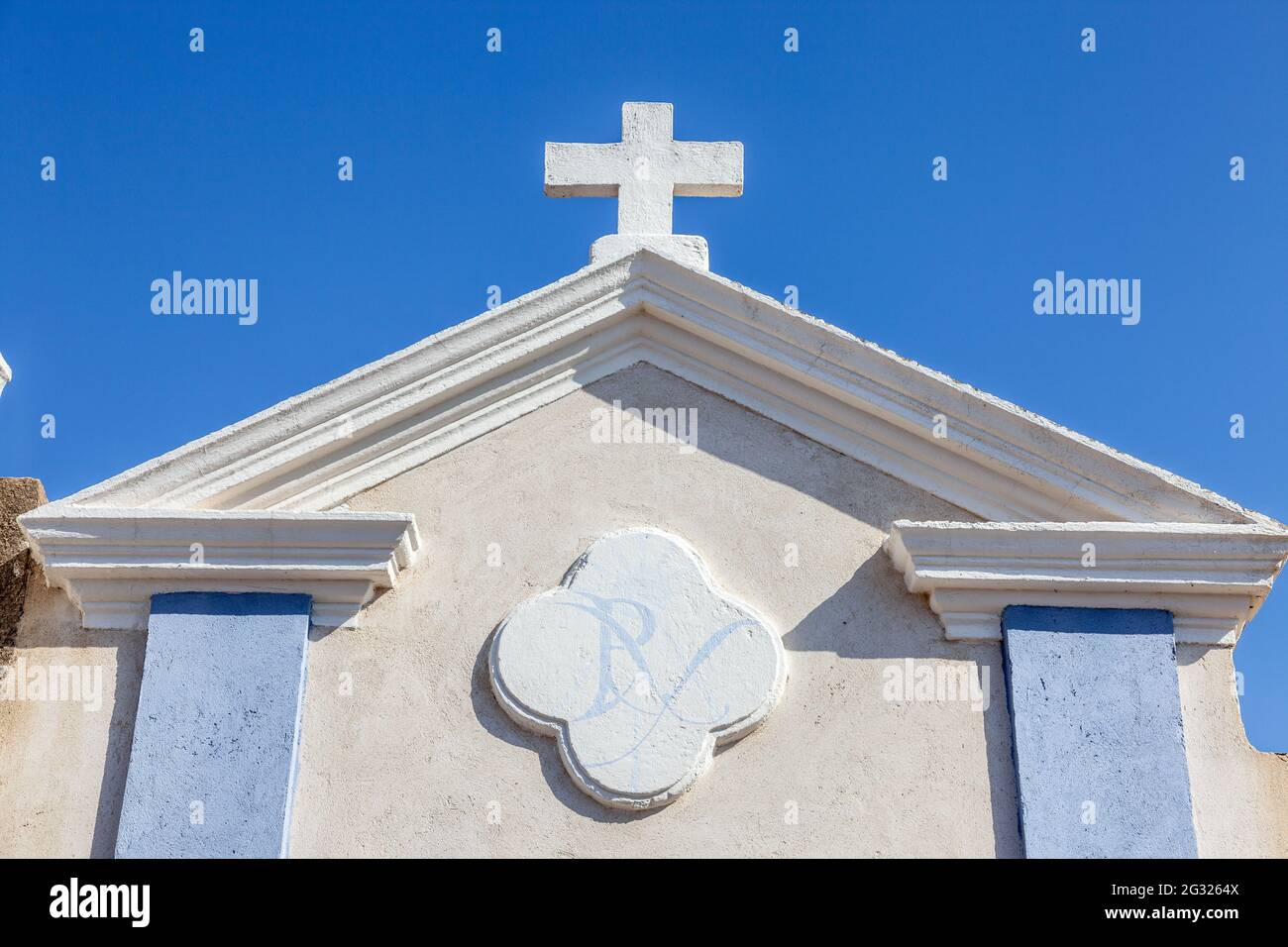 Croix sur le fronton d'une voûte funéraire. Bleu et blanc. Cimetière marin de Bonifacio. Corse, France Banque D'Images