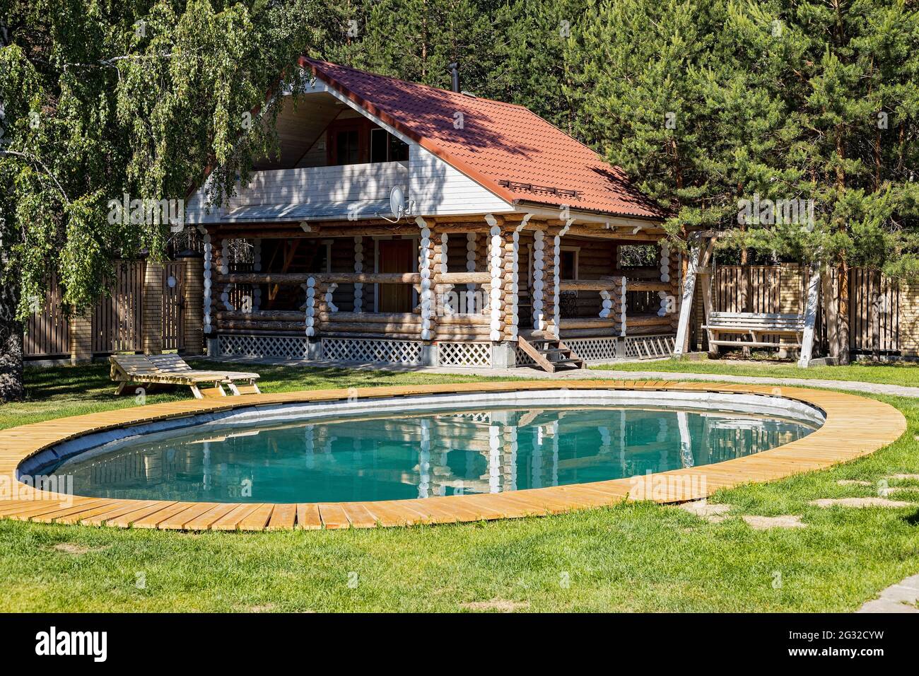 Maison moderne en bois avec toit carrelé, piscine et patio. Solide cottage en bois pour un séjour confortable et la vie en dehors de la ville. Banque D'Images
