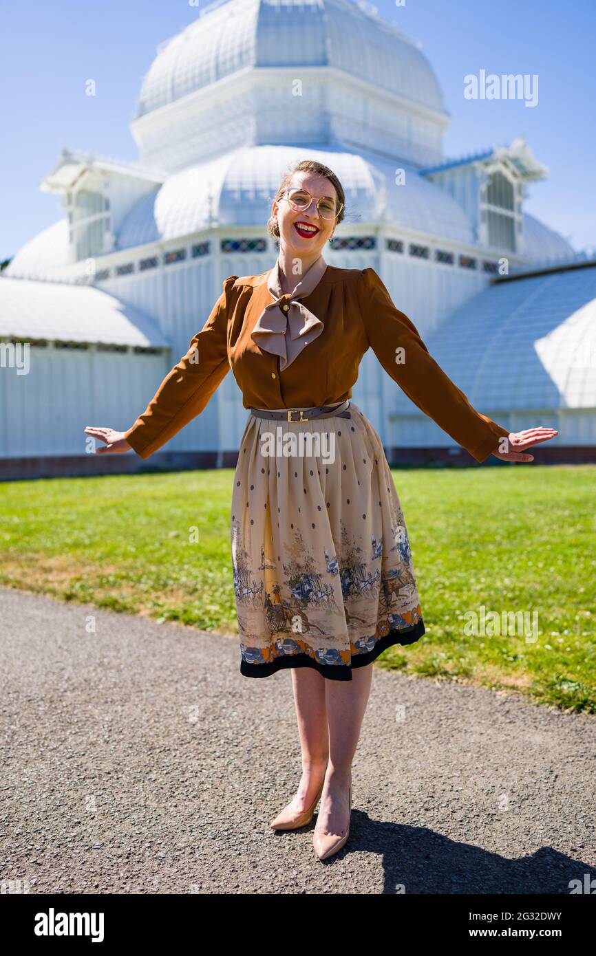 Jeune femme dans les années 1940 vêtements devant le conservatoire de l'époque victorienne Banque D'Images