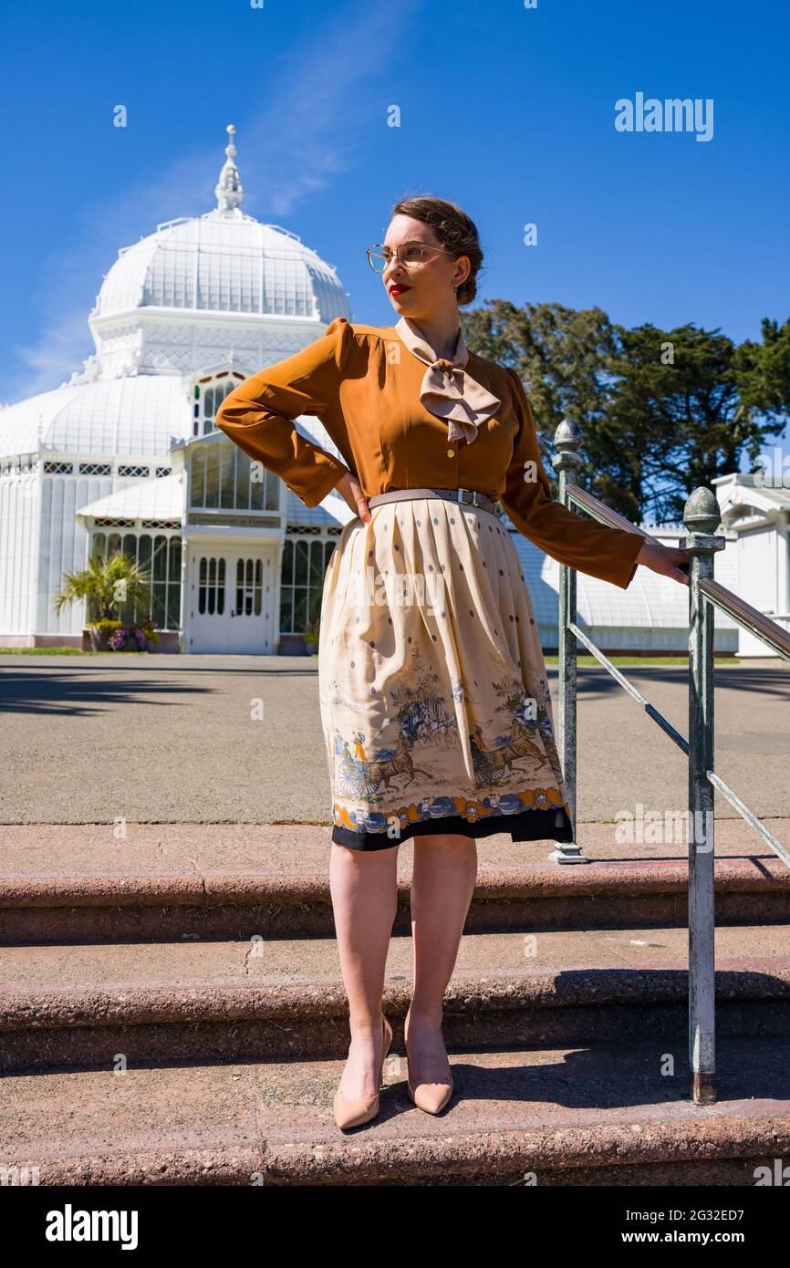 Jeune femme dans les années 1940 vêtements devant le conservatoire de l'époque victorienne Banque D'Images