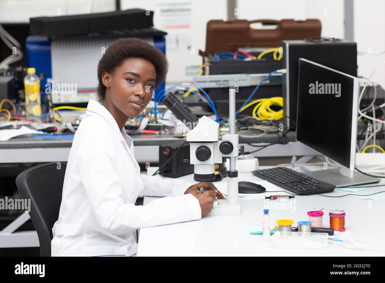 Scientifique afro-américaine femme travaillant en laboratoire avec des instruments de technologie et un microscope. Recherche et développement de dispositifs électroniques par couleur noire femme. Banque D'Images