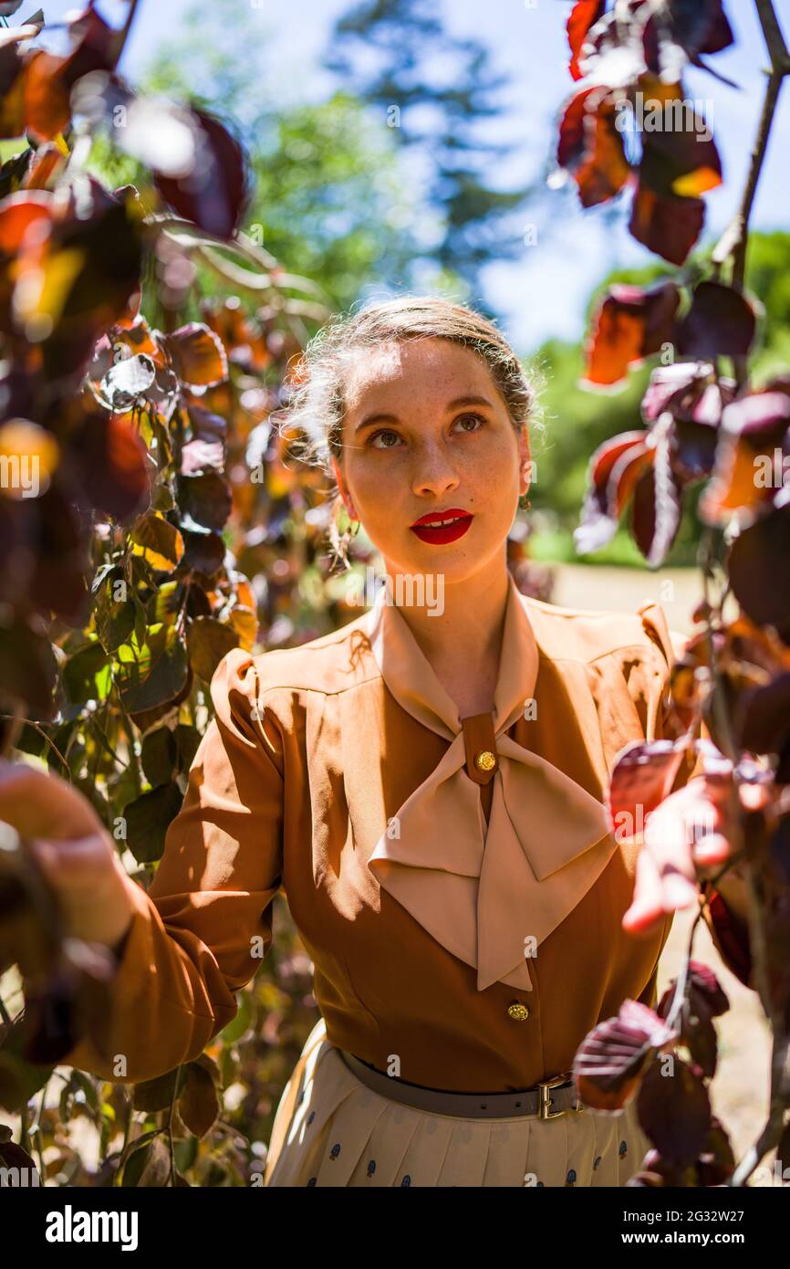 Jeune femme dans la mode des années 1940 dans le parc Banque D'Images
