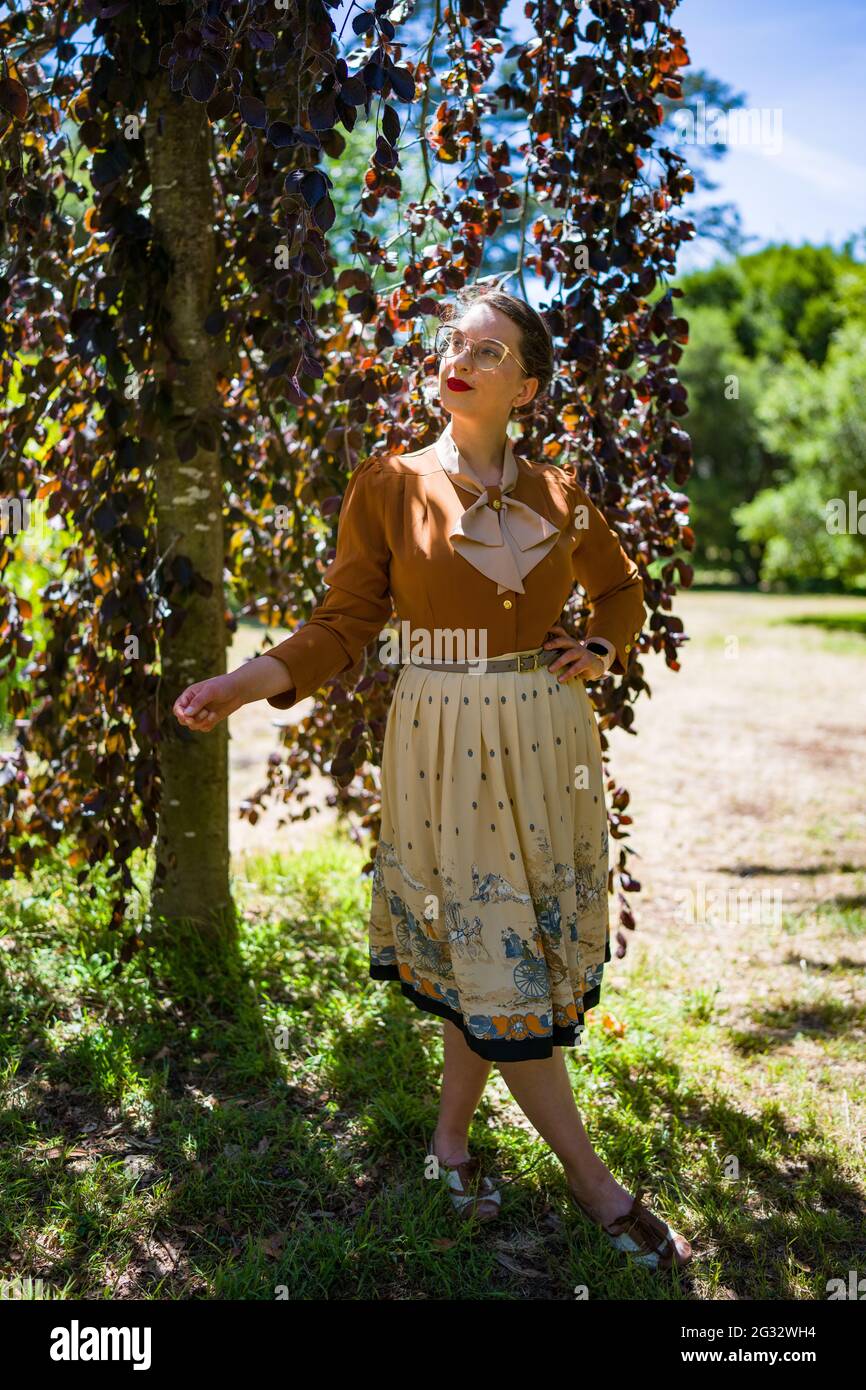 Jeune femme dans la mode des années 1940 dans le parc Banque D'Images