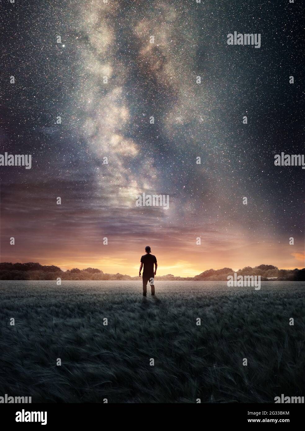Un homme explorant le ciel nocturne tandis que la galaxie de la voie lactée remplit le paysage d'en haut. Photo composite Banque D'Images