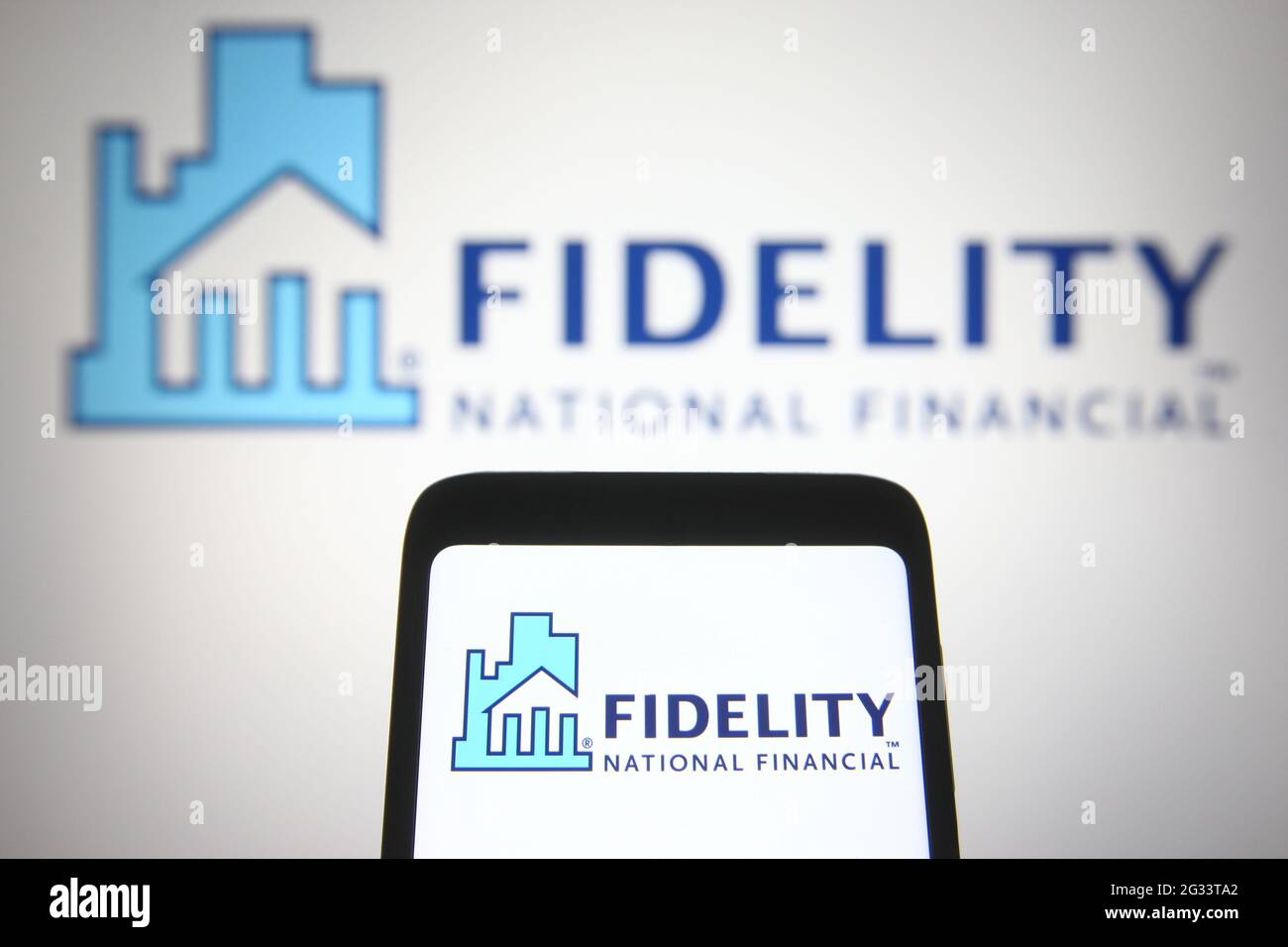 Dans cette illustration photo, un logo Fidelity National Financial (FNF) apparaît sur un smartphone et un écran de pc. Banque D'Images