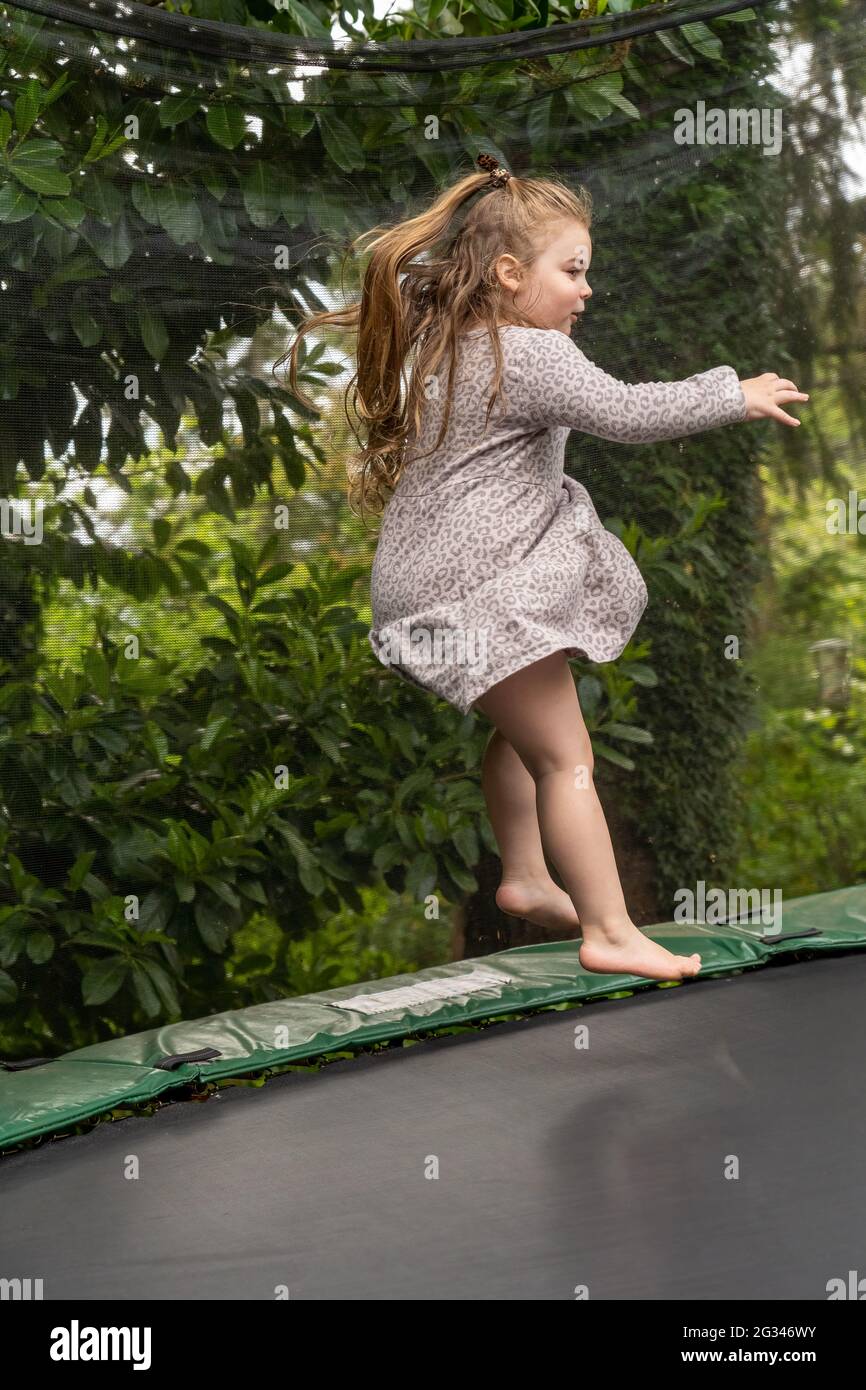 Lynwood, Washington, États-Unis. une fille de 4 ans rebondit sur son trampoline. (M.) Banque D'Images