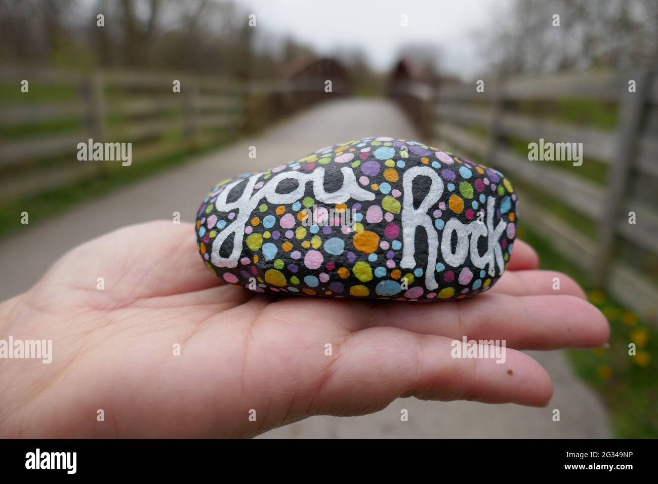 La gentillesse du rock avec le message de rock peint vous et les pois colorés tenus sur la main de gros plan Banque D'Images
