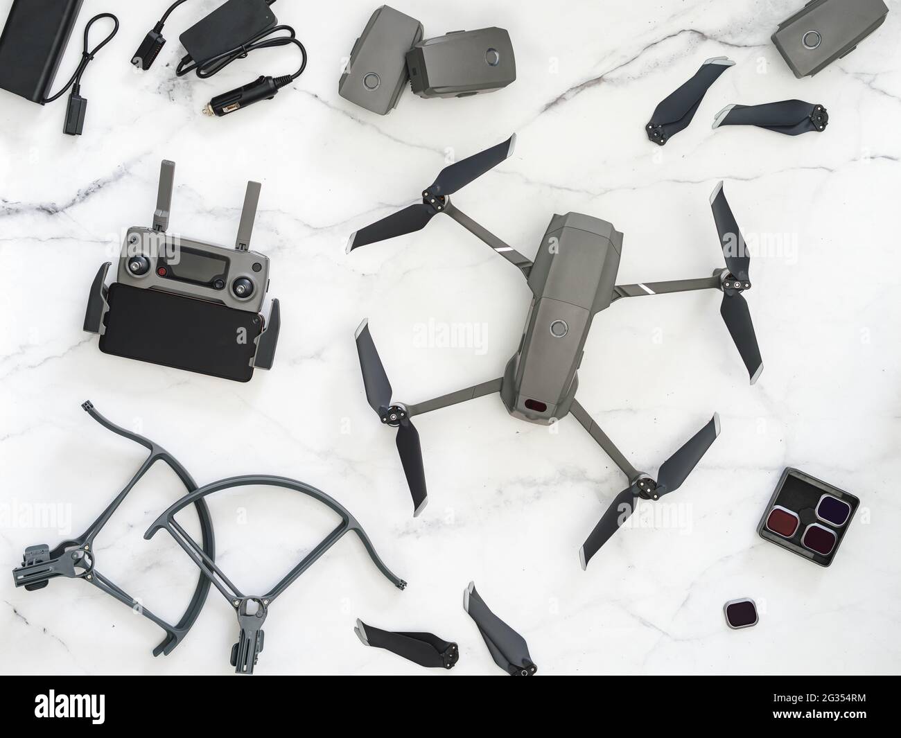 Jeu de drone pliable ou de quadcopter avec de nombreux accessoires, vue de dessus ou plat. Kit de drone pliant et équipement pour UAV sur fond de marbre blanc. Banque D'Images