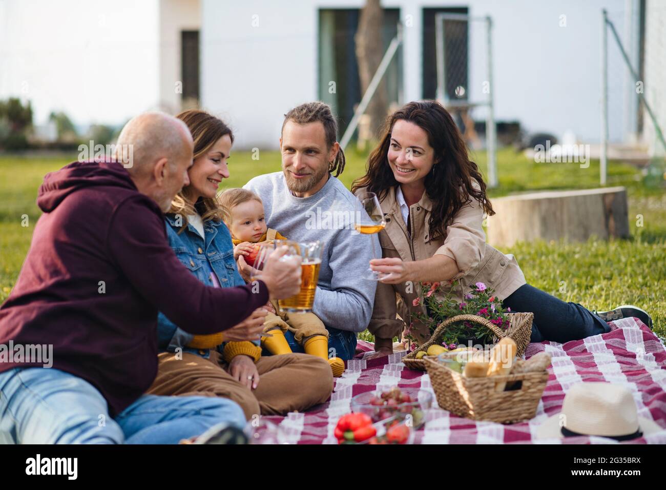 Bonne famille de plusieurs générations à l'extérieur, pique-nique dans le jardin de l'arrière-cour. Banque D'Images