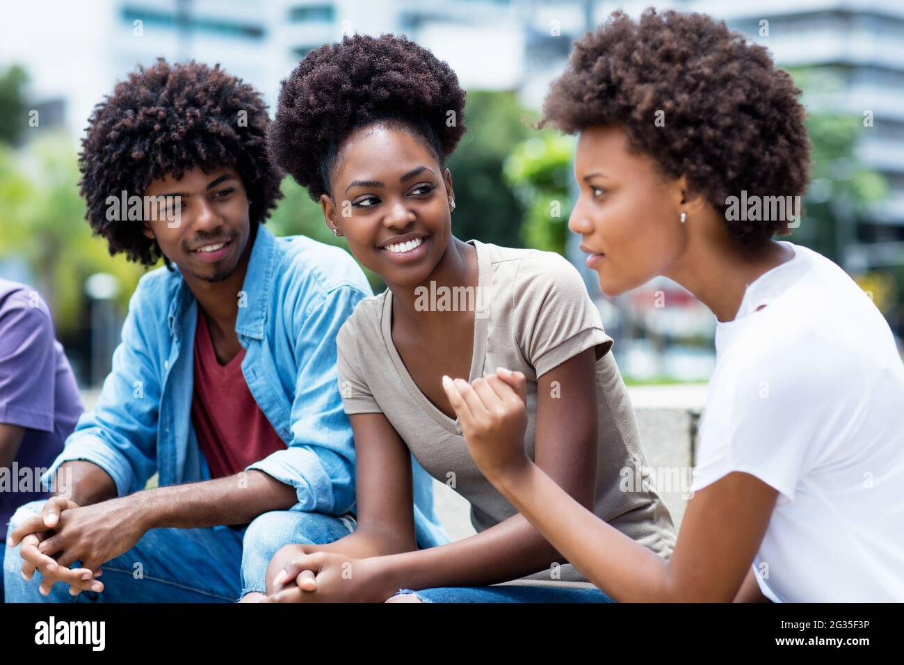 Jeunes adultes afro-américains en discussion en plein air en été dans la ville Banque D'Images