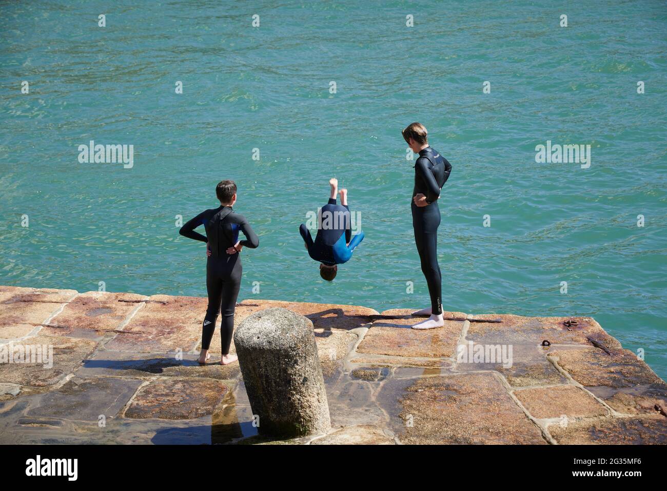 Destination touristique Cornish Porthleven, Cornouailles, Angleterre, enfants sautant dans l'eau Banque D'Images