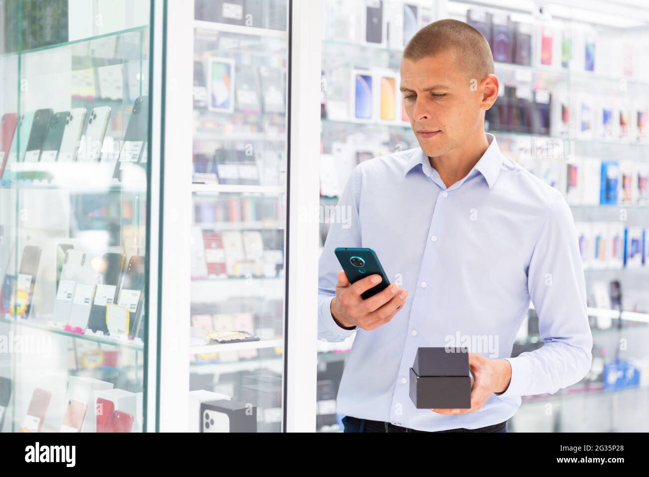 Homme acheteur choisir le téléphone à la boutique multimédia Banque D'Images