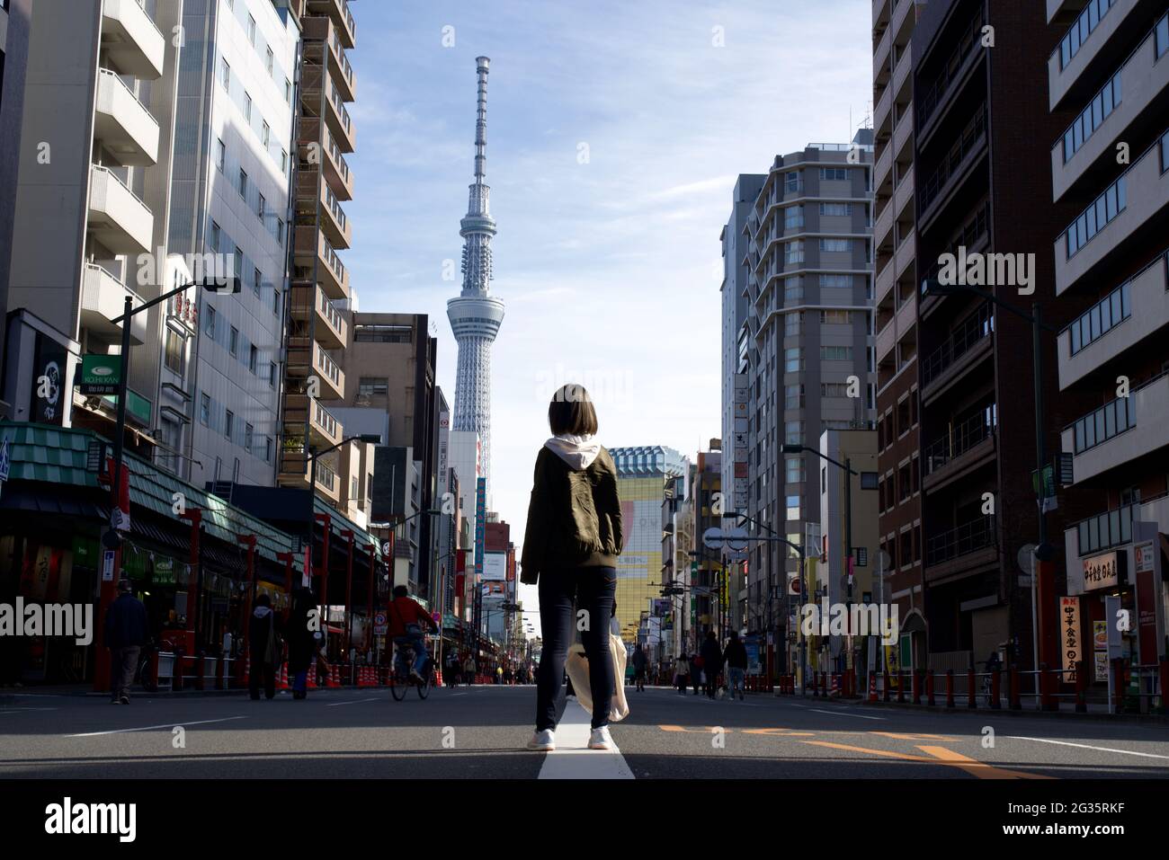 Vue arrière de la femme asiatique qui est en tête de la vue de Tokyo Sky Tree et du siège social d'Asahi Group depuis la rue Kaminarimon-Dori, Asakusa, Tokyo, Japon Banque D'Images