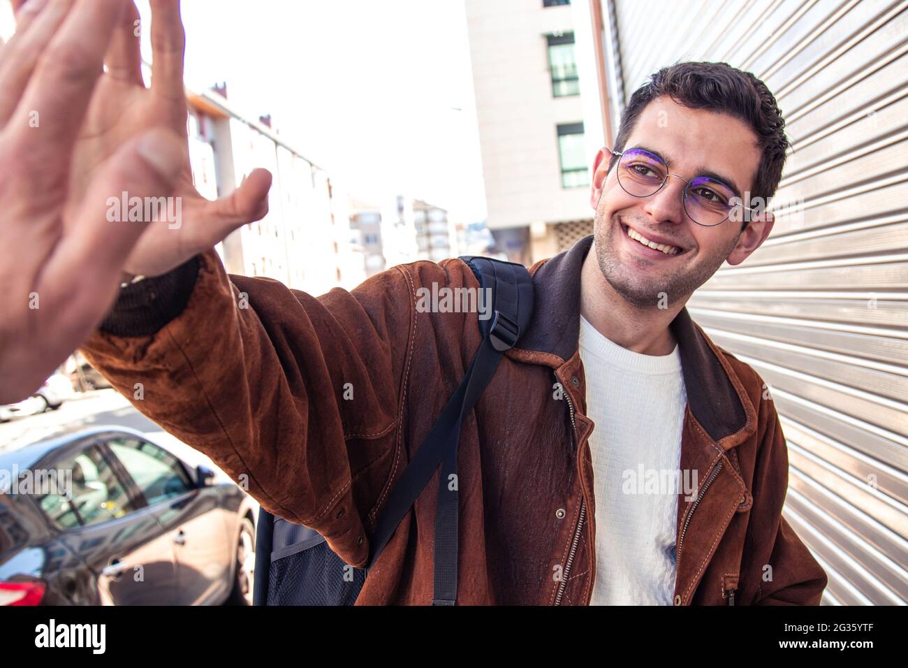 jeune homme souriant agitant dans la rue Banque D'Images