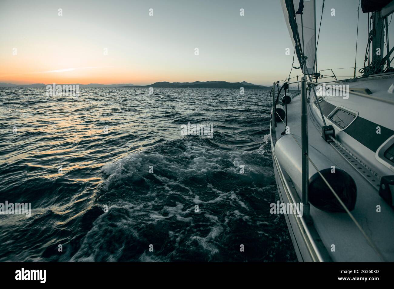 Bateau à voile yacht de luxe dans la mer pendant le coucher du soleil. Banque D'Images