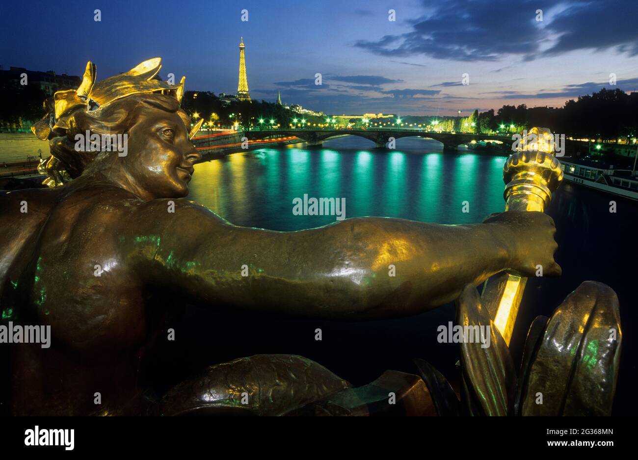 FRANCE PARIS (75) STATUE : NYMPHE DE LA SEINE SUR LE PONT ALEXANDRE III ET TOUR EIFFEL LA NUIT Banque D'Images