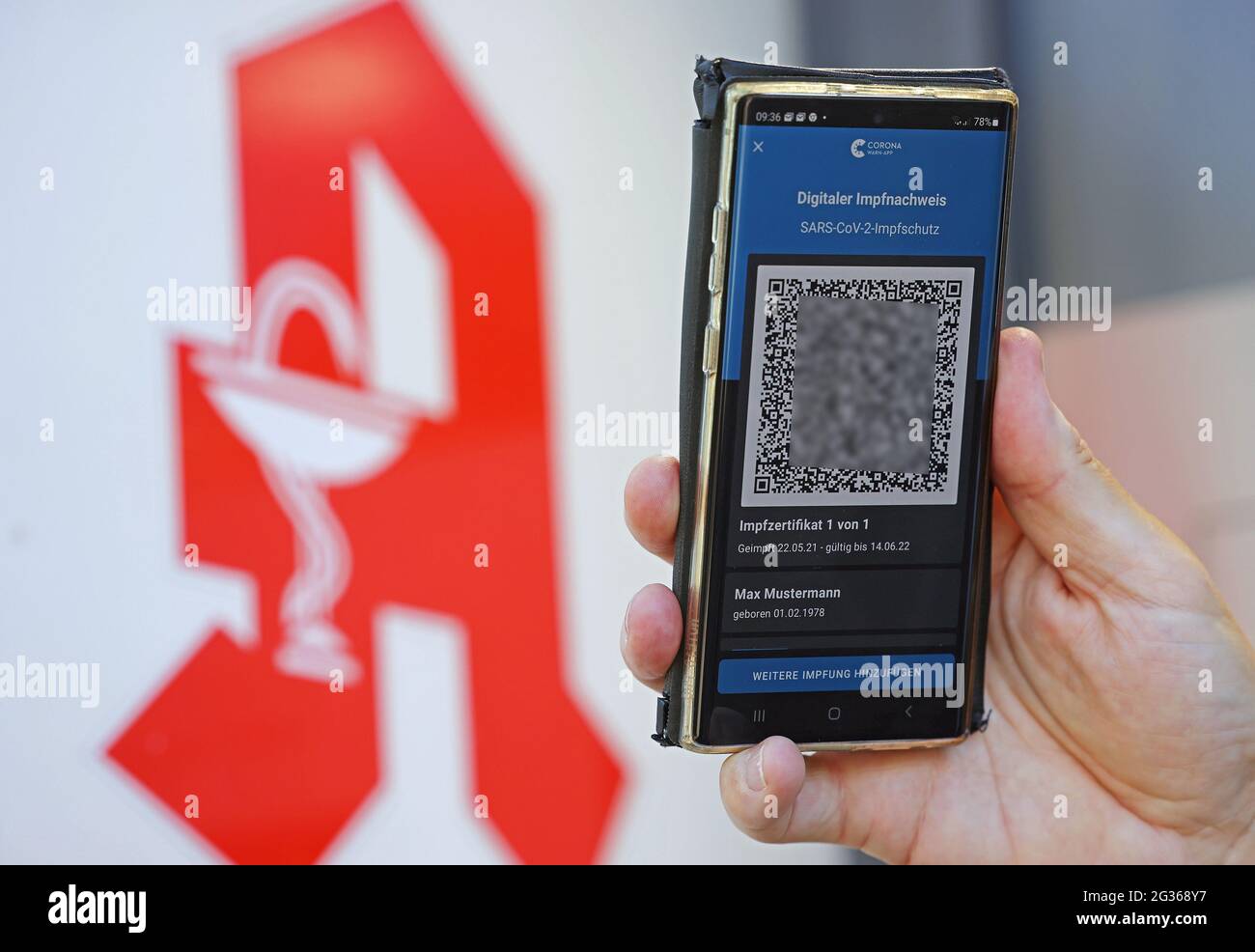 Cologne, Allemagne. 14 juin 2021. La preuve numérique de la vaccination est visible devant le logo de la pharmacie sur un smartphone. Certains pharmaciens commencent à émettre la nouvelle preuve numérique d'un vaccin Corona. Cela implique la création d'un code QR pour les personnes entièrement vaccinées qui peuvent être utilisées dans des applications avec leur téléphone. Credit: Oliver Berg/dpa - ATTENTION: Le code QR a été pixelated pour des raisons juridiques/dpa/Alay Live News Banque D'Images