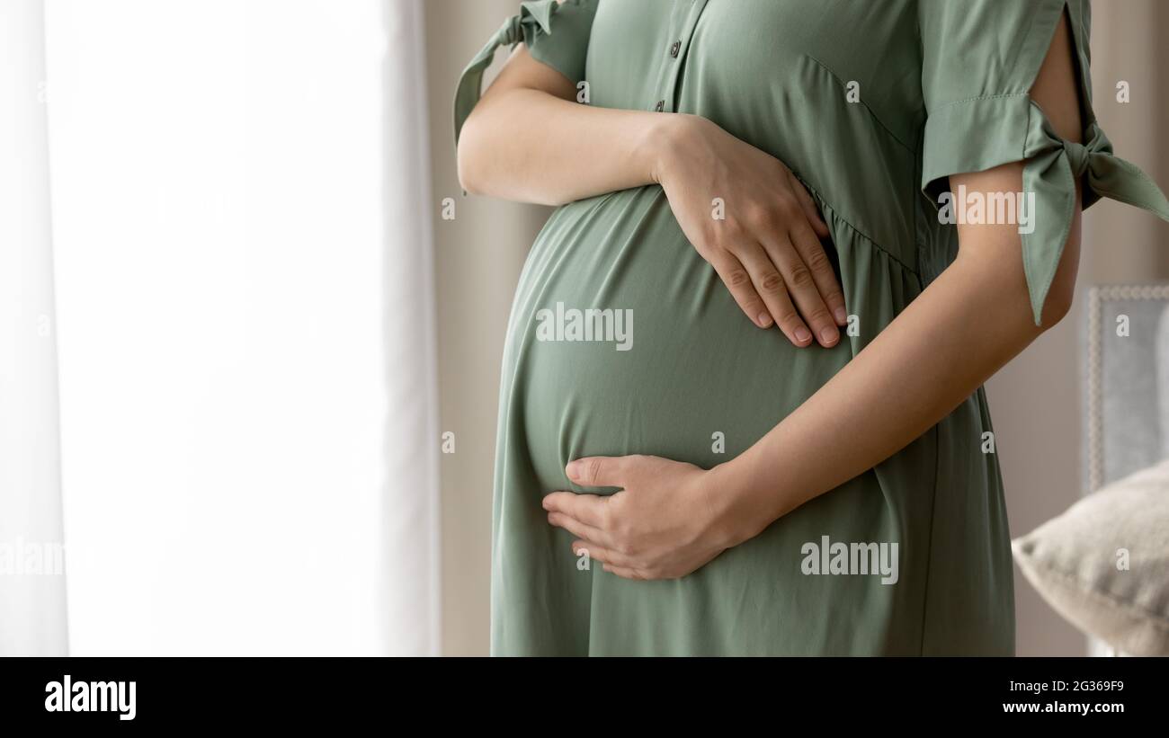 Gros plan court de femme enceinte en robe sur le ventre Banque D'Images