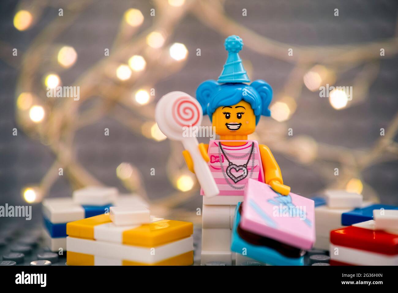 Tambov, Fédération de Russie - 17 janvier 2021 Lego Giant minifigure avec lolipop et cadeaux contre la plaque de base grise avec le dos lumineux de noël Banque D'Images
