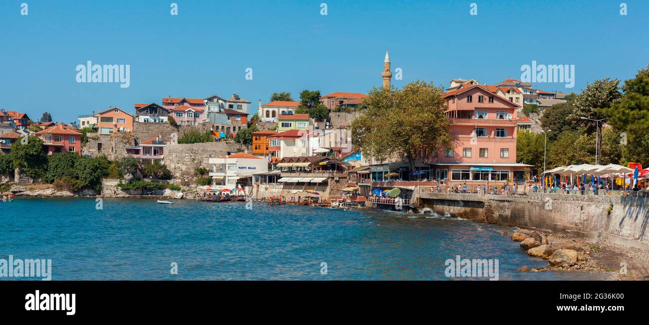 Amasra, Turquie-1er septembre 2011 : vue panoramique des célèbres restaurants de poissons avec des personnes qui déjeunent, des serres colorées et le littoral près de la plage d'Amasra. Banque D'Images