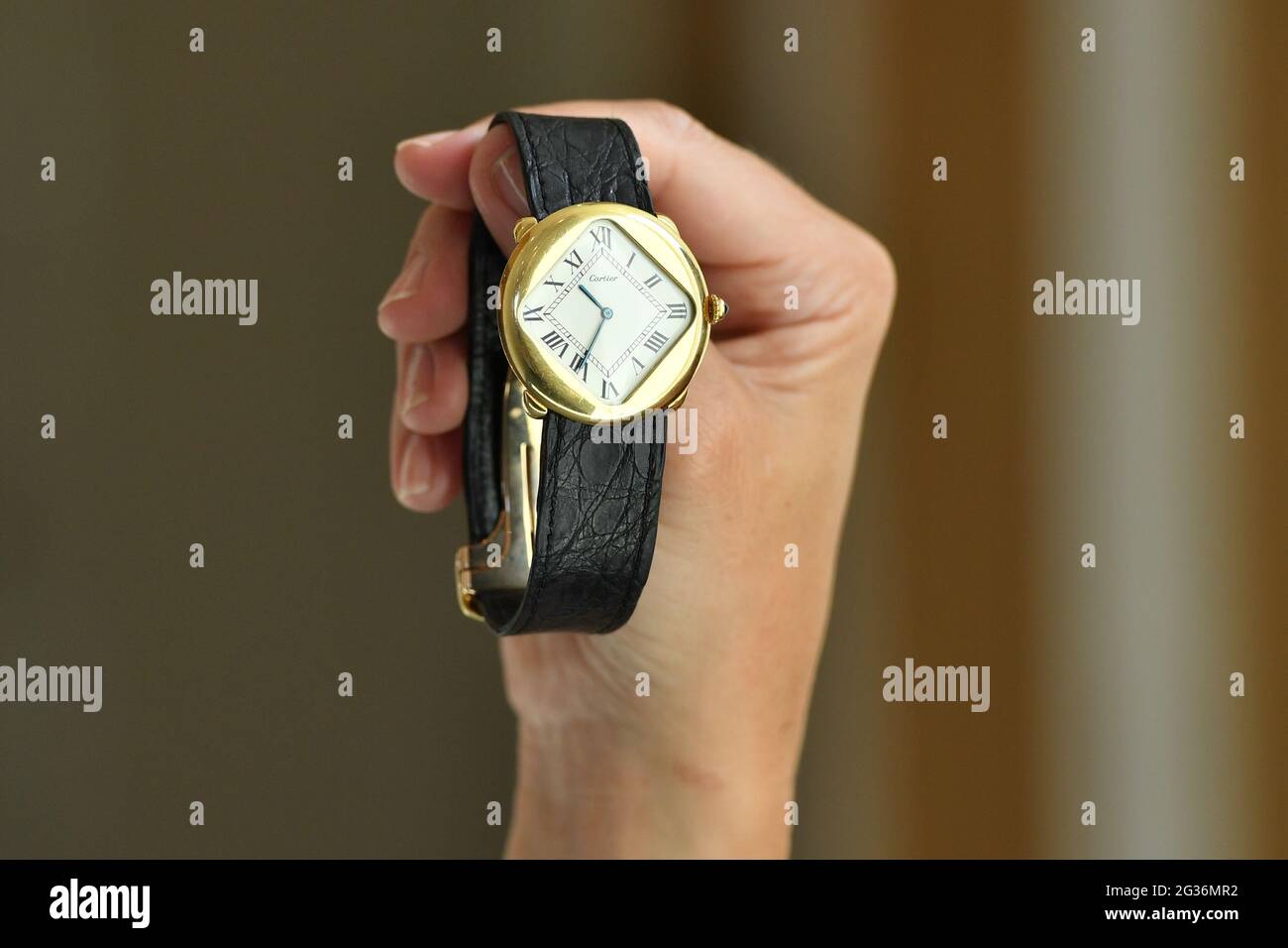 Un membre du personnel tient une montre d'or 1975 Pebble 'Turtle' Cartier  18k, avec une valeur de vente estimée de £150,000-£200,000, lors d'un  aperçu de la Bonhams Fine Watches sale, à Bonhams