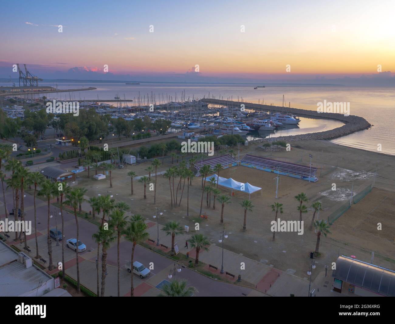 Vue aérienne de dessus surplombant la pause de la journée dans le port de la vieille ville de Larnaca, Chypre. Yachts dans la mer Méditerranée, terrain de volley à la plage. Banque D'Images