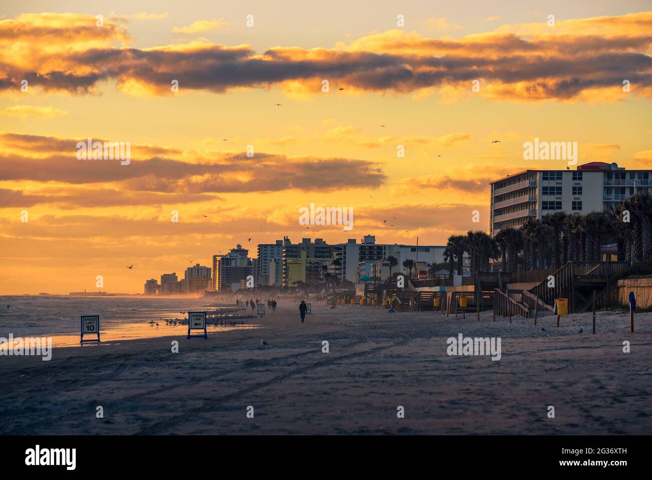 Côte de Daytona Beach en Floride au lever du soleil avec les gens et palmiers Banque D'Images