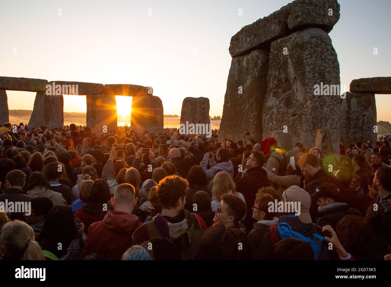 Les premiers rayons du soleil entrent dans le cercle intérieur du monument néolithique Stonehenge sur la plaine de Salisbury le jour du solstice. Angleterre, Royaume-Uni. Banque D'Images