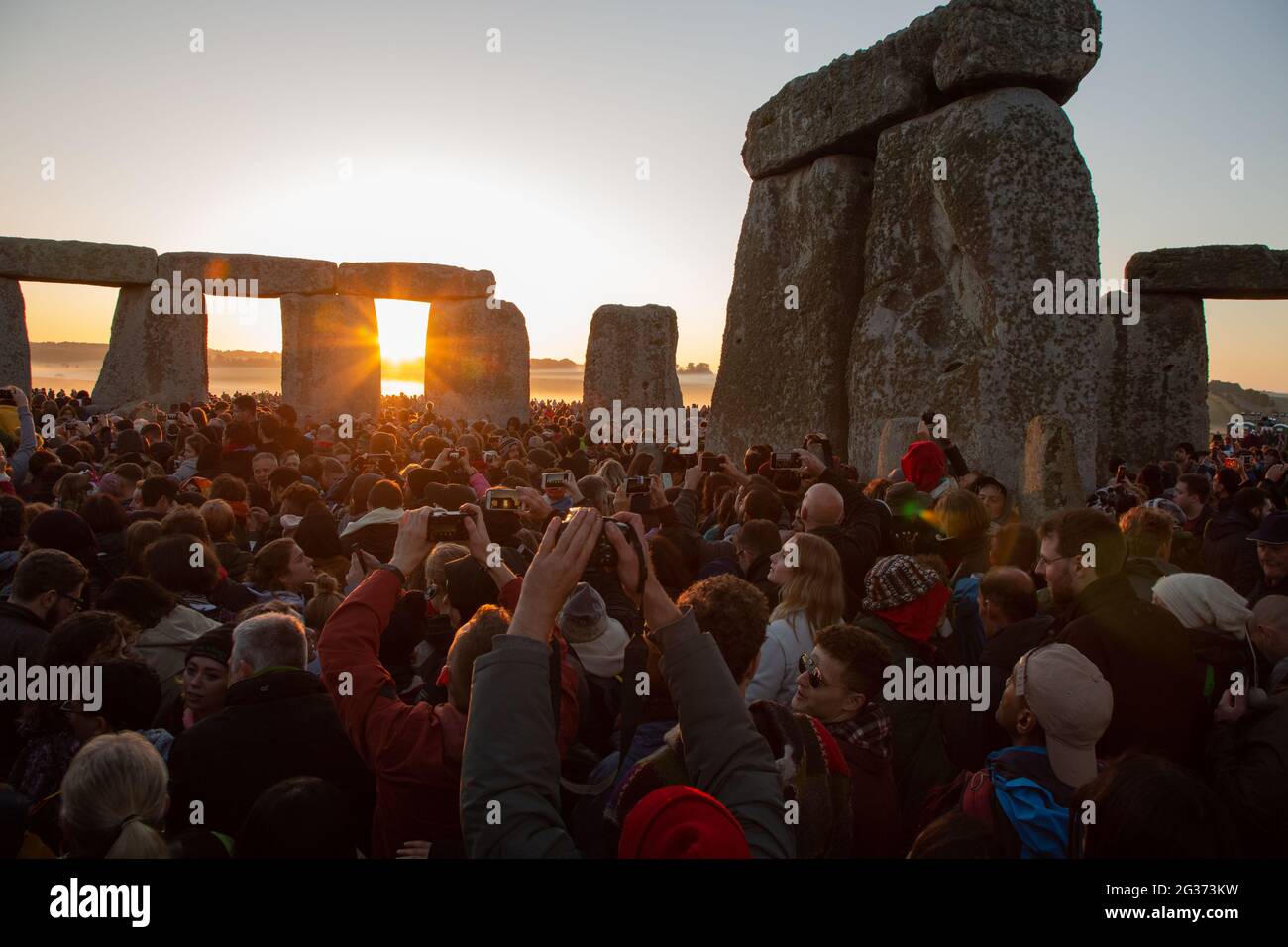 Les premiers rayons du soleil entrent dans le cercle intérieur du monument néolithique Stonehenge sur la plaine de Salisbury le jour du solstice. Angleterre, Royaume-Uni. Banque D'Images