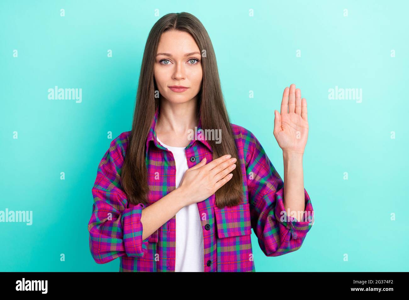 Photo de grave longue coiffure jeune femme priez porter une chemise à carreaux isolée sur fond de couleur teal vive Banque D'Images