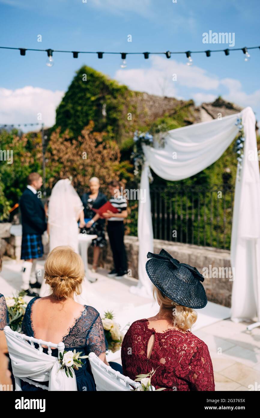 Cérémonie de mariage avec une mariée dans une robe de mariage, un marié dans une robe nationale écossaise et des invités dans de beaux vêtements Banque D'Images