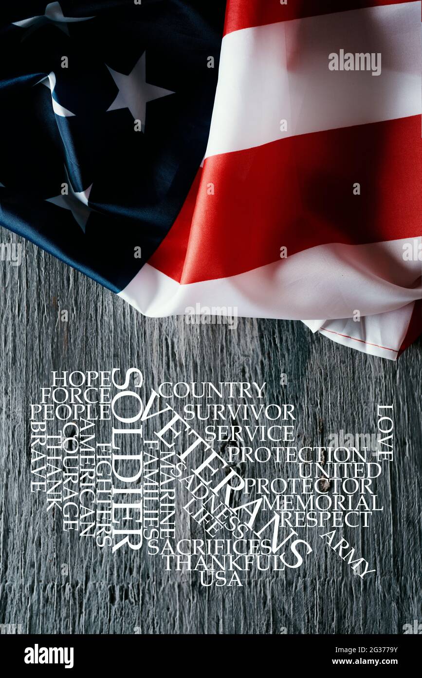 Un drapeau américain sur une surface en bois rustique gris et un nuage de balises, en forme de carte des états-unis, avec des mots pour honorer les anciens combattants militaires et Banque D'Images