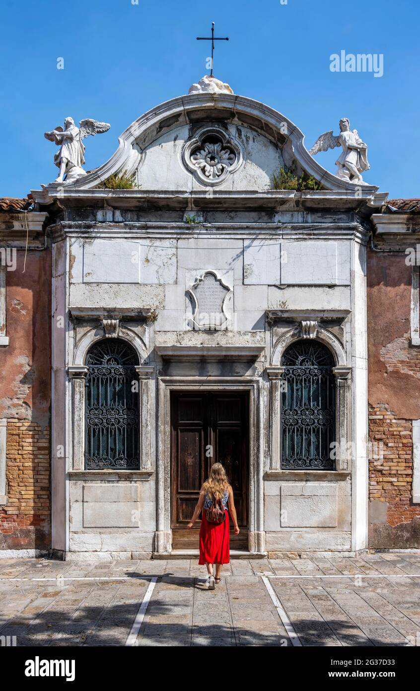 Touriste en robe rouge devant une maison, Murano, Murano, Venise, Vénétie, Italie Banque D'Images