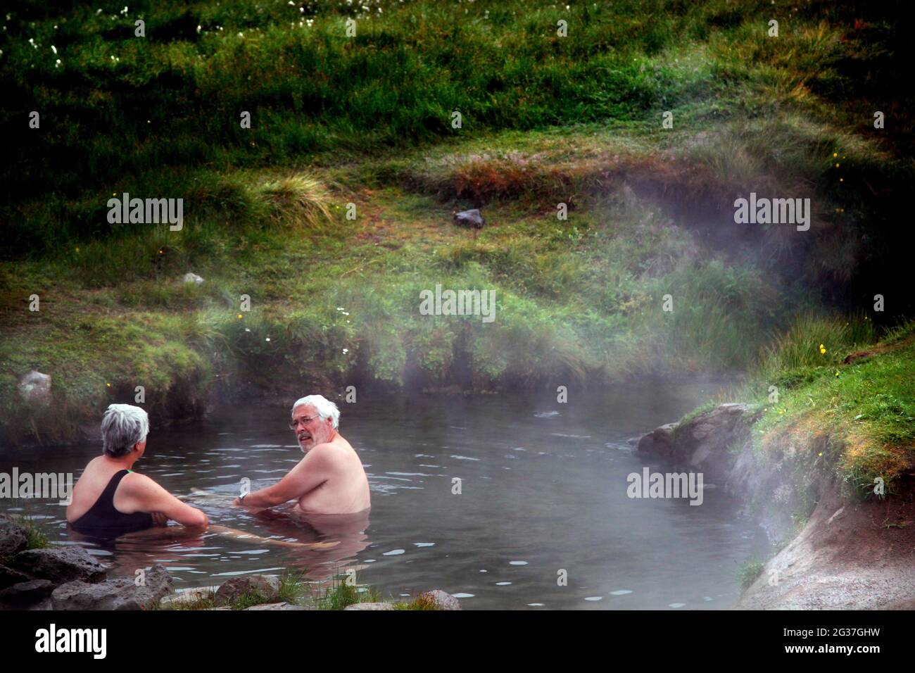 Piscine naturelle, hot pot, source géothermique, couple de baignade Reykjafjaroarlaug, Vestfiroir, Westfjords, Islande Banque D'Images