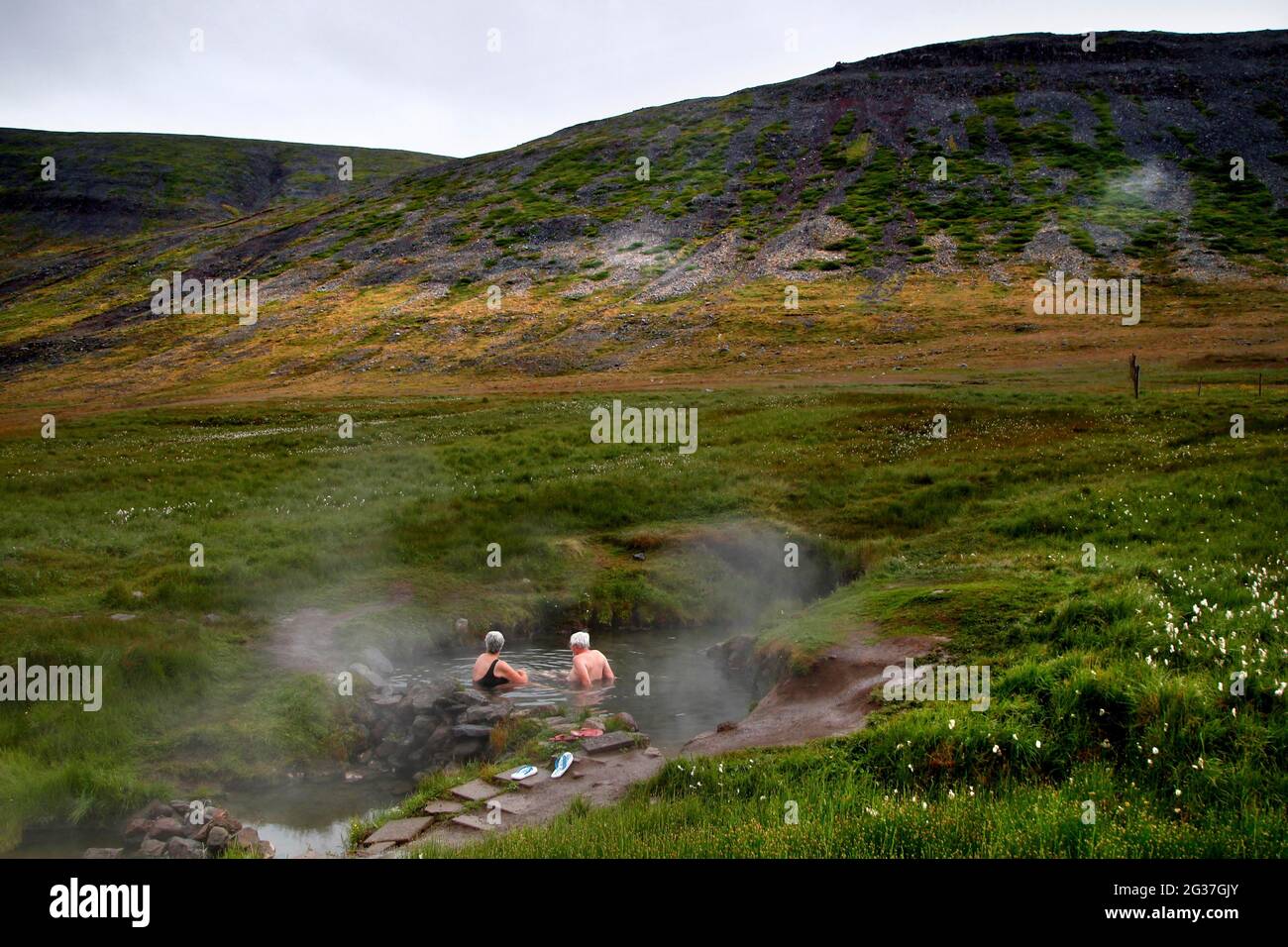 Piscine naturelle, hot pot, source géothermique, couple de baignade Reykjafjaroarlaug, Vestfiroir, Westfjords, Islande Banque D'Images