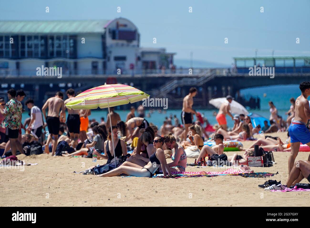 Les gens sur la plage de Bournemouth, comme le temps chaud continue, avec des prévisionnistes avertissant du risque d'averses orageux vers la fin de la semaine. Banque D'Images