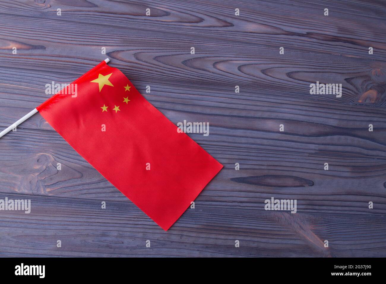 Drapeau de Chine à vagues rouges sur fond de bureau en bois gris. Banque D'Images
