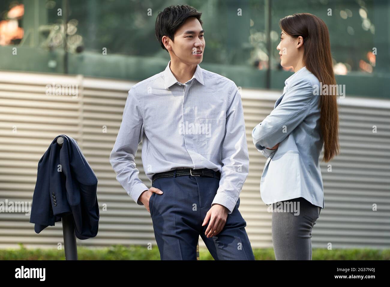 deux jeunes gens d'affaires asiatiques debout dans la rue discutant conversant Banque D'Images