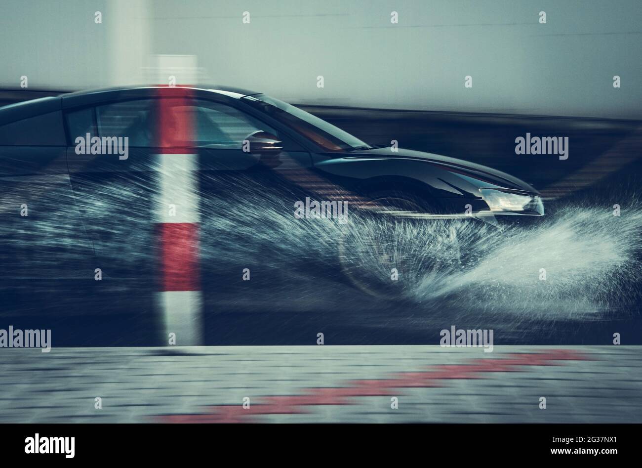 Une voiture moderne de performance qui se fait traverser l'eau. Thème de conduite urbaine avec flou de mouvement. Industrie automobile. Concept d'aquaplaning ou d'hydroplaning. Banque D'Images