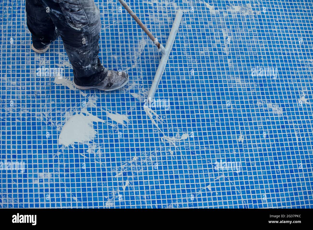 L'employé qui couvre les noms de la tuile dans la piscine. Travaux de réparation de piscine Banque D'Images