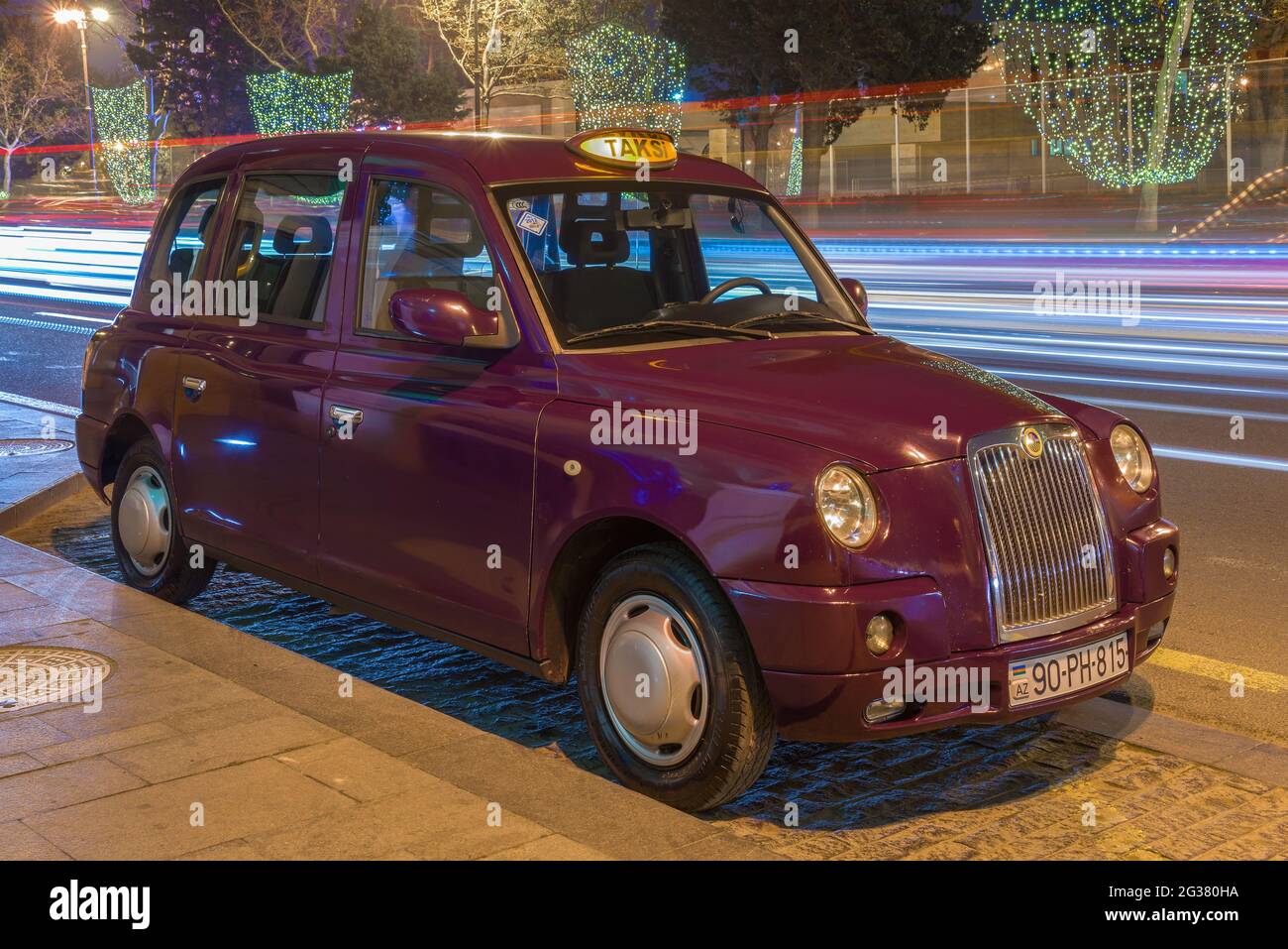 BAKOU, AZERBAÏDJAN - 04 JANVIER 2018 : taxi « London taxi TX4 » de couleur pourpre sur une rue nocturne Banque D'Images