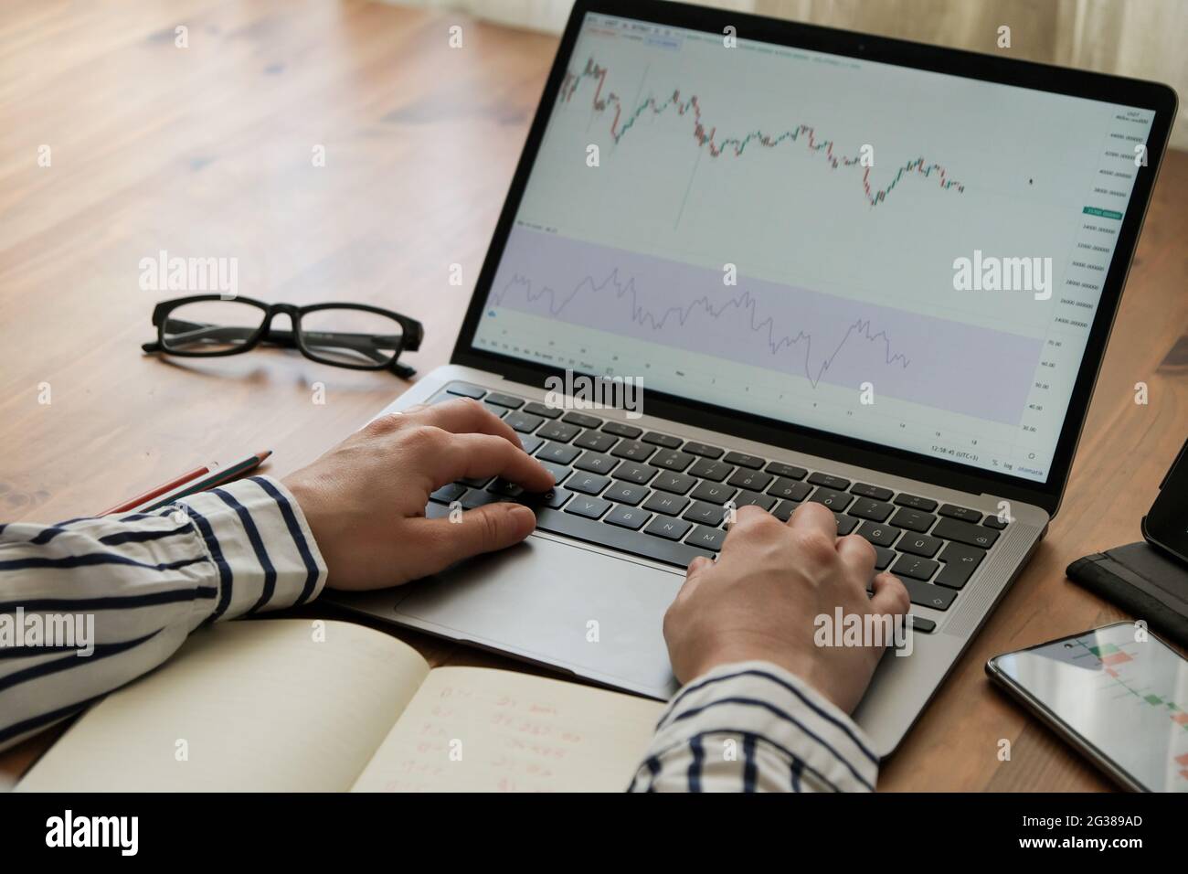 business woman examine les graphiques boursiers avec un ordinateur portable Banque D'Images