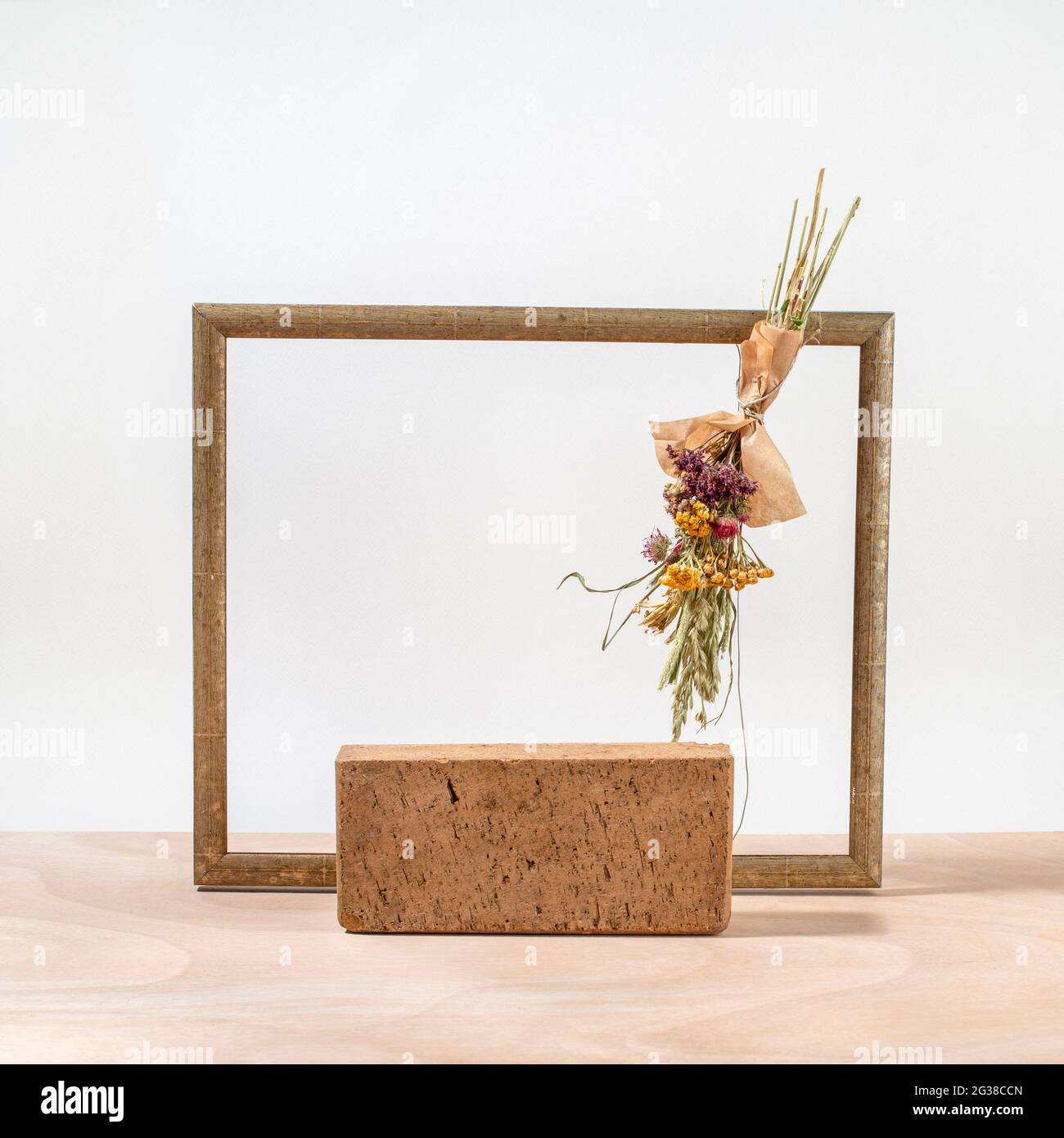 Composition minimale de podium en brique, cadre en bois et bouquet d'herbes séchées. Modèle, maquette, podium pour les produits et accessoires. Vue avant. Banque D'Images