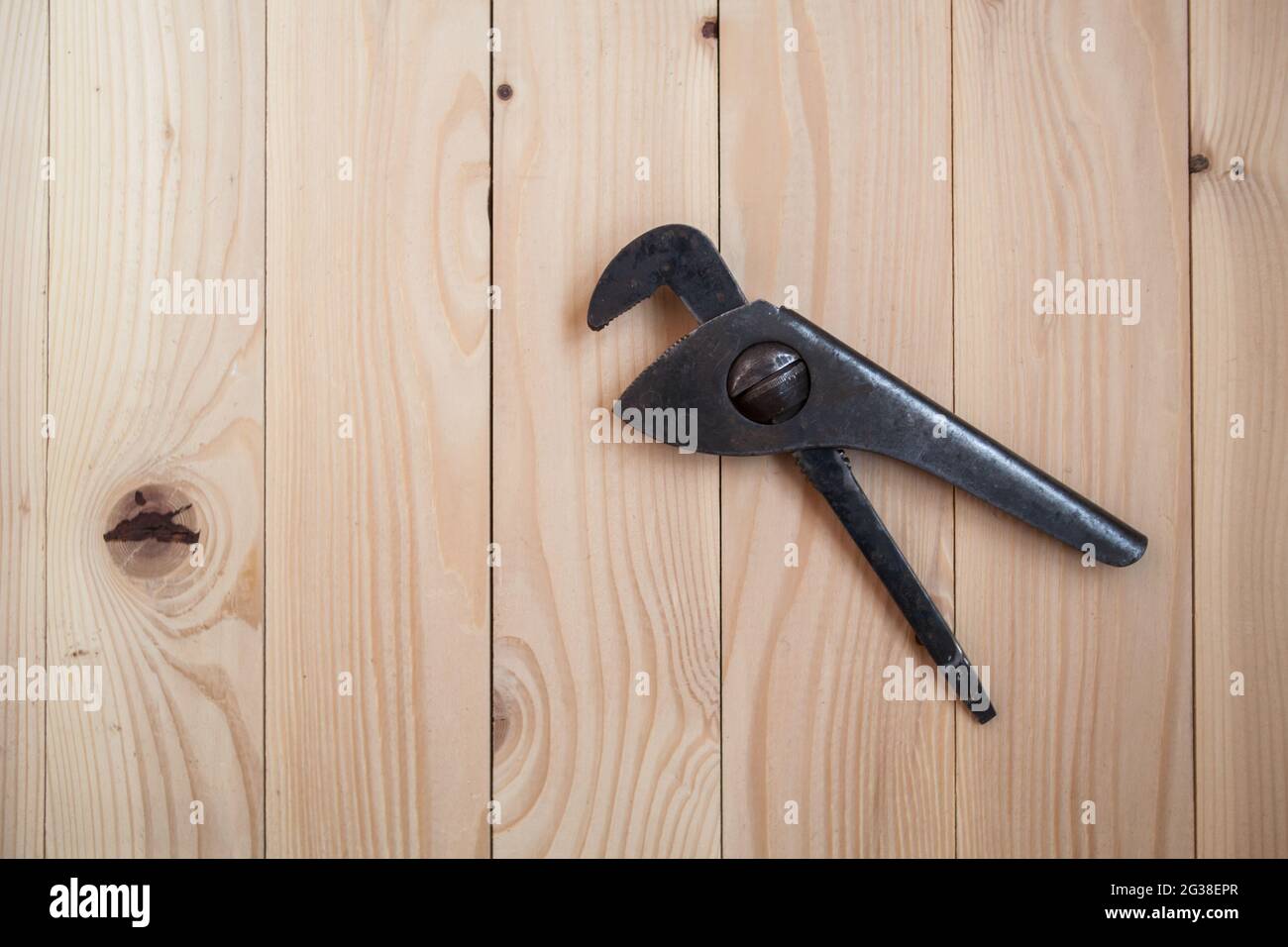 Ancienne clé à tube réglable sur fond en bois clair. Clé de plomberie. Concept de rénovation. Banque D'Images